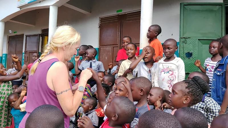 A visitor spending time with children at His Grace Junior School